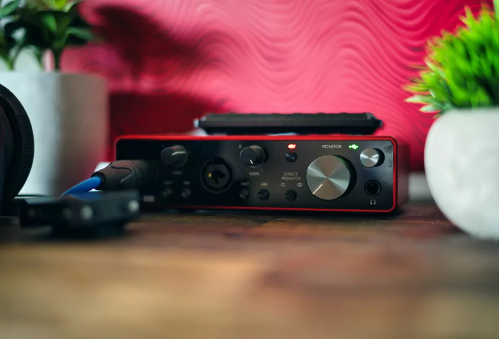 Photograph of red audio equipment (Scarlet Interface), with desktop plants.